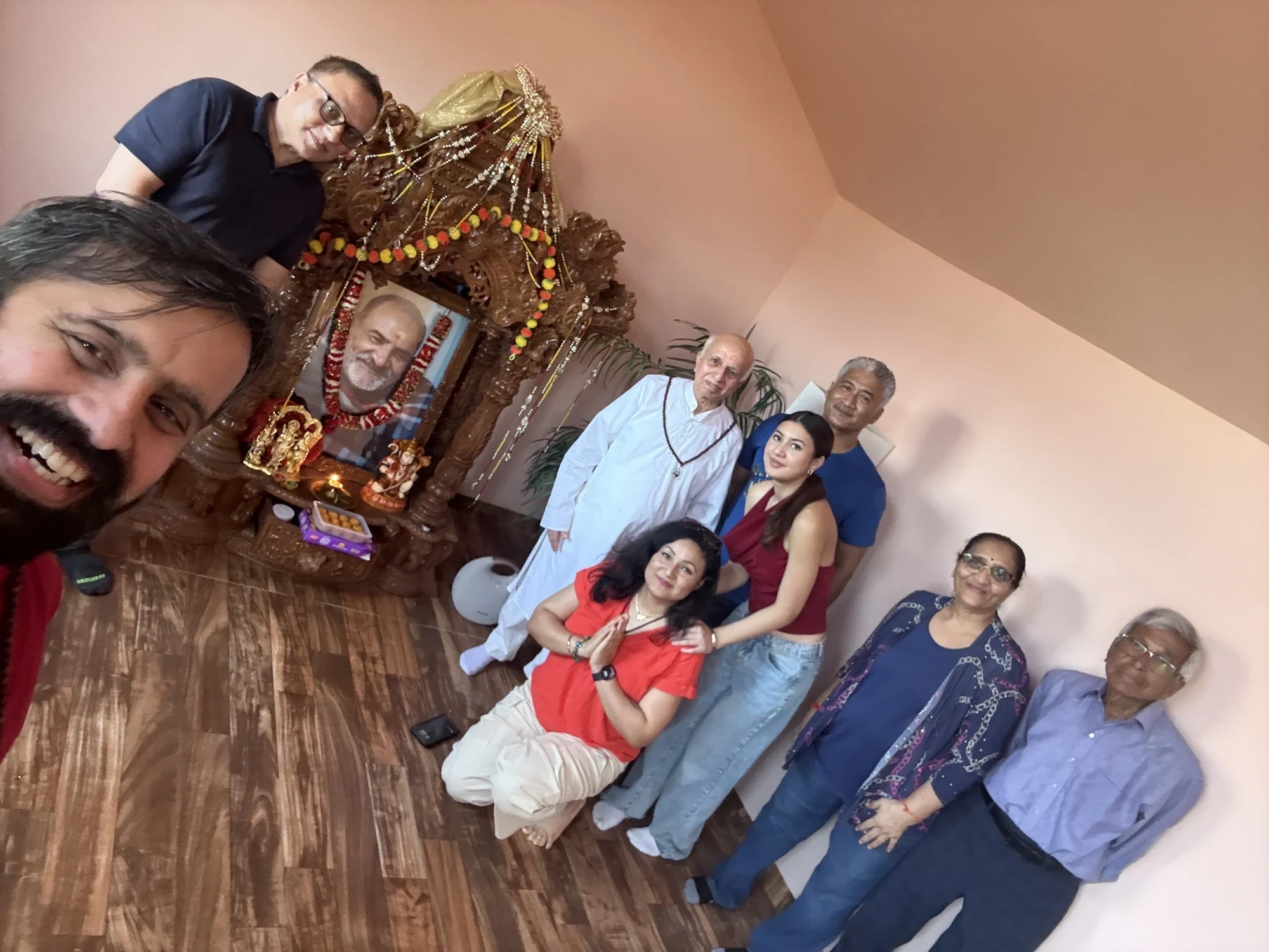 Devotees gathered around Baba's garlanded portrait at the Denison mandir